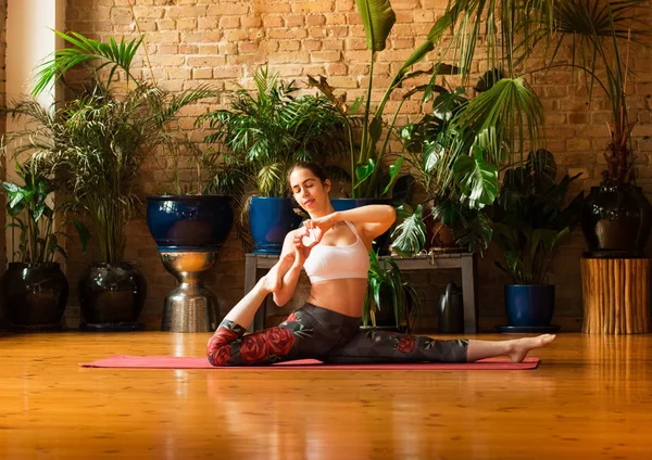 Mujer joven y delgada practicando yoga en estudio — Foto de Stock