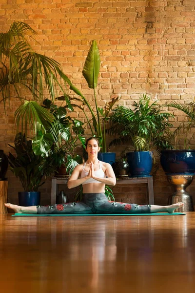 Jalá Mujer joven practicando yoga en estudio. Sentado en la alfombra verde . — Foto de Stock