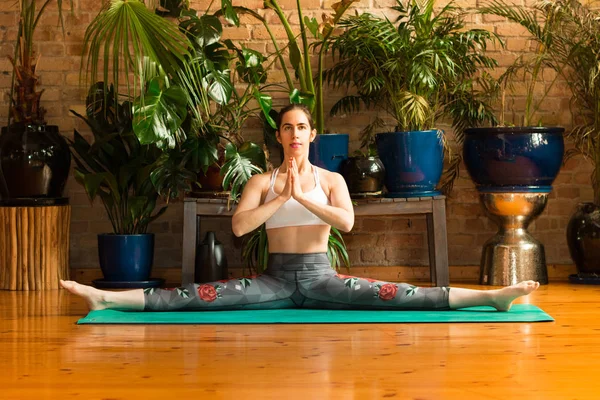 Jalá Mujer joven practicando yoga en estudio. Sentado en la alfombra verde . — Foto de Stock