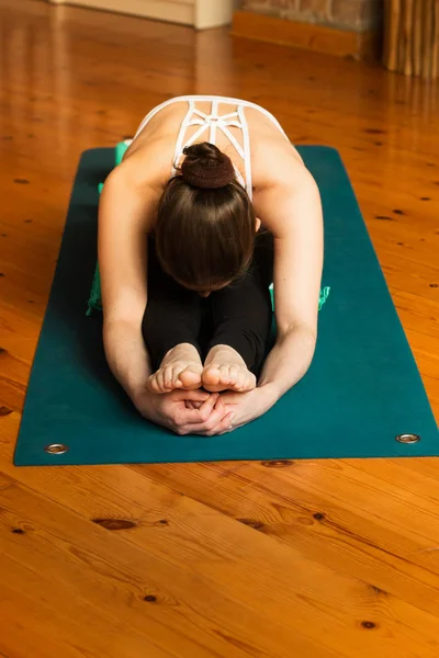 En ung kvinne som praktiserer yoga i studio . – stockfoto