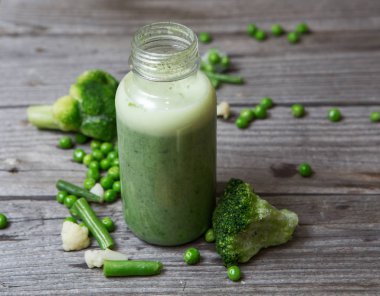 Sağlıklı sebze güler yüzlü bir mason bir kavanoz içinde bir rustik ahşap arka plan