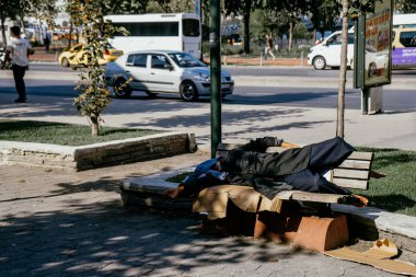 Istanbul, Türkiye - Eylül 2018: Uyuyan sürtük ayakkabı olmadan sıcak güneşin altında ahşap bir bankta