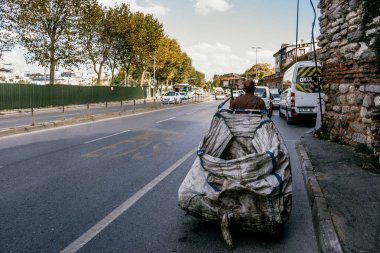 Istanbul, Türkiye - Eylül 2018: Büyük çöp torbası ile yolda yürüyen hademe günlük çalışmalarını