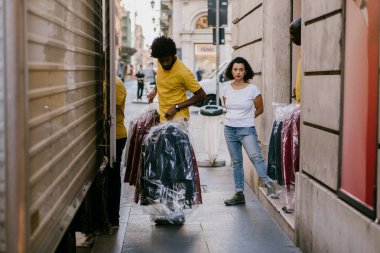 Roma, İtalya - 12 Eylül 2018: Çalışanlar mağazadan arabaya şık kıyafetler taşıyor
