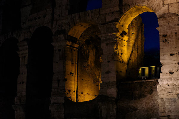 Beautiful ancient Colosseum in the late evening, illuminated in the window yellow light | ROME, ITALY - 12 SEPTEMBER 2018.