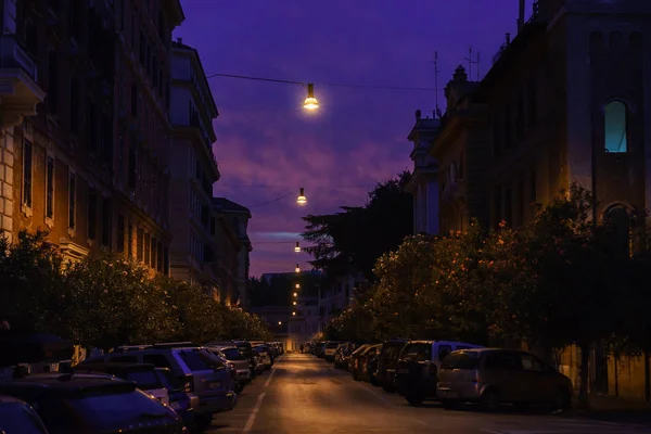 Roma caddesinde gün doğumu, mor gökyüzü, park halindeki arabalar | Roma, İtalya - 12 Eylül 2018.
