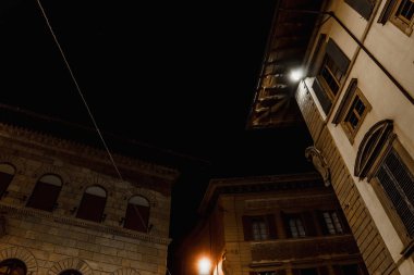 Geçen yüzyıla kadar uzanan, taştan yapılmış büyük evlerin ahşap çatı, gece görünümü | Floransa, İtalya - 14 Eylül 2018.