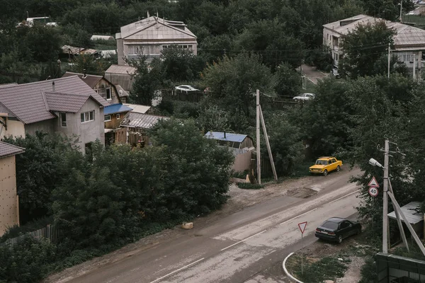 Zhiguli sarı arabası yola park edilmiş, modern Rusya yaz günü, Yukarı Pyshma-124 'ün tuğla ve ahşap binaları; Yukarı Pyshma, Rusya - 15.08.2018.