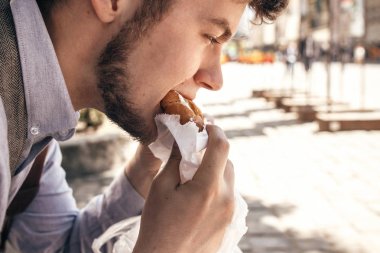 sokak lokanta kavramı. şık hipster man lezzetli hamburger, yemek görünümü kapatın