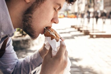 sokak lokanta kavramı. şık hipster man lezzetli hamburger, yemek görünümü kapatın