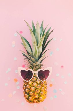 şık ananas konfeti trendy pembe kağıt zemin üzerine pembe güneş gözlüğü. düz yatıyordu. yaz tatil ve parti genel kavram. metin için yer. yaz seyahat ve tatil