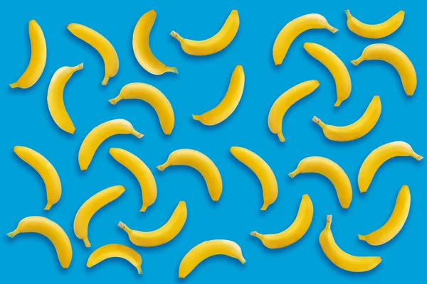 banana pattern. yellow bananas on blue paper background, trendy flat lay. summer concept