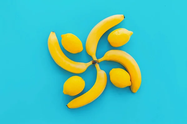 Bananas Amarelas Círculo Com Limões Sobre Papel Azul Moderno Fundo — Fotografia de Stock