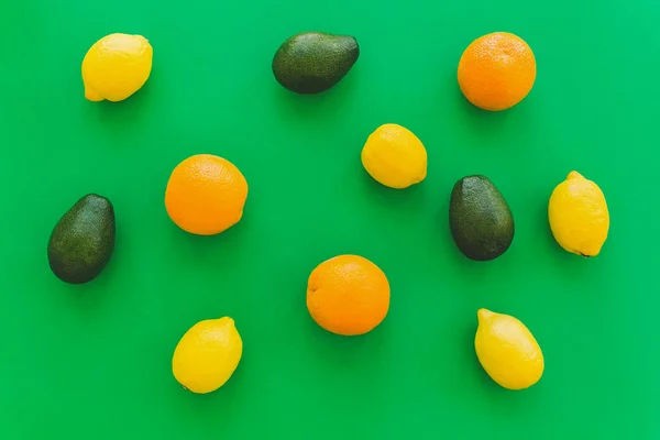 Πορτοκάλια Αβοκάντο Και Λεμόνια Φωτεινό Πράσινο Χαρτί Μοντέρνα Φόντο Επίπεδη — Φωτογραφία Αρχείου