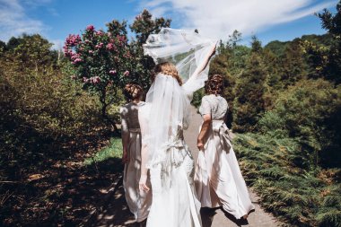 güneşli parkta eğleniyor, dans ve gün zevk nedime ile mutlu muhteşem gelin. bahçede düğün töreni