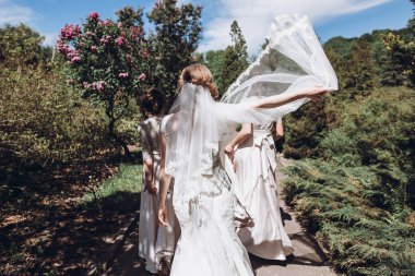 güneşli parkta eğleniyor, dans ve gün zevk nedime ile mutlu muhteşem gelin. bahçede düğün töreni