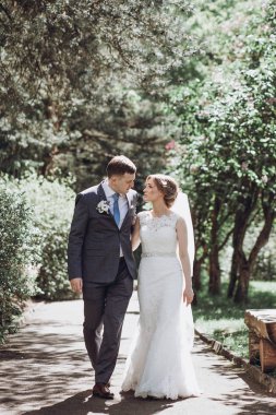güzel güzel gelin ve damat güneşli bahar Park'ta yürüyordunuz ve gün, tam uzunlukta zevk
