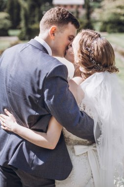 güzel güzel gelin ve damat güneşli bahar parkta öpüşme ve gün zevk. mutlu evlilik çift yeşil bahçesinde rahatlatıcı. mutlu bir evlilik anlar. kaçış kavramı