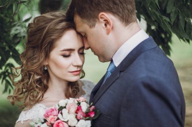 Romantik düğün anı, açık havada buket, Genç aile portresi, güzel gelin ve aşık yakışıklı damat ile sarılma yeni evli çift