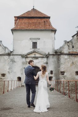 güzel güzel gelin ve damat yürüyüş. sarılma ve eski kalede kucaklayan mutlu evlilik çift. mutlu romantik anlar. kaçış kavramı. şehvetli aşk. metin için yer