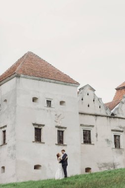 güzel güzel gelin ve damat açık havada poz. sarılma ve eski kalede kucaklayan mutlu evlilik çift. mutlu romantik anlar. kaçış kavramı. şehvetli aşk. metin için yer