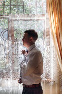 Yakışıklı mutlu Damat Düğün, kendine güvenen işadamı toplantı için sabah düğün hazırlık konsept hazırlama önce şık beyaz gömlek üzerine koyarak