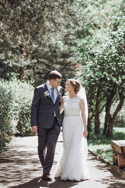 güzel güzel gelin ve damat güneşli bahar Park'ta yürüyordunuz ve gün, tam uzunlukta zevk