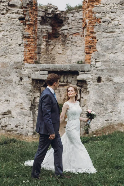 güzel güzel gelin ve damat yürüyüş ve birbirine bakarak. mutlu evlilik çift eski kalede kucaklayan. mutlu romantik anlar. kaçış kavramı. şehvetli aşk. metin için yer