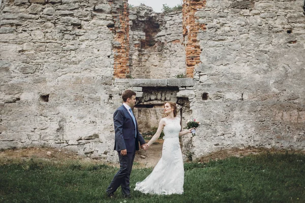 Pasgetrouwde Echtpaar Poseren Buurt Van Oude Kasteelmuur Sprookjesachtige Bruiloft Het — Stockfoto