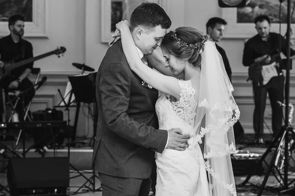 Romantic newlyweds first dance at luxury restaurant, monochrome