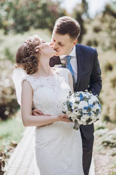 güzel güzel gelin ve damat güneşli bahar parkta öpüşme ve gün zevk. mutlu evlilik çift yeşil bahçesinde rahatlatıcı. mutlu bir evlilik anlar. kaçış kavramı