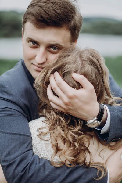 Όμορφος Groom Αγκαλιάζοντας Όμορφη Νύφη Και Εξετάζοντας Φωτογραφική Μηχανή Ευτυχισμένος — Φωτογραφία Αρχείου