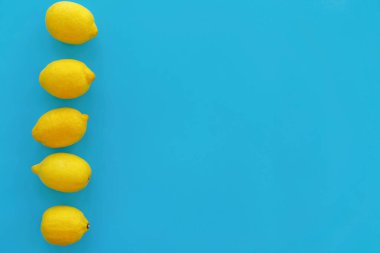 trendy düz sarı limon çizgi parlak mavi kağıt üzerinde yatıyordu. meyve modern resim, üstten görünüm. sulu yaz vitamin ve beslenme kavramı. pop sanat tarzı. yaratıcı minimalizm. metin için yer