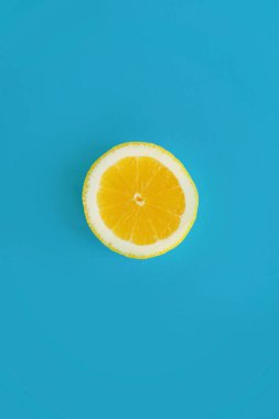 sarı dilim limon parlak mavi kağıt üzerinde trendy düz yatıyordu. meyve modern resim, üstten görünüm. sulu yaz vitamin ve beslenme kavramı. pop sanat tarzı. yaratıcı minimalizm desen