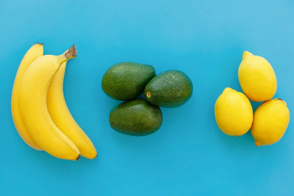 果物グループ トレンディなフラットが横たわっていた バナナ アボカド 明るい青色の紙にレモン モダンな夏のイメージ コンセプト フラット マルチ フルーツを産むが — ストック写真
