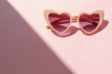 pembe güneş gözlüğü güneş ışığı içinde moda pembe Kağıt arka plan üzerinde. düz yatıyordu. yaratıcı kontrast yaz görüntü. Tatil ve parti genel kavram. metin için yer. tropikal yaz tatili