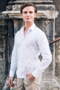 güneşli sokakta poz güzel yakışıklı adam. güvenle ayakta ve gülümseyen şık hipster damat. zarif işadamı