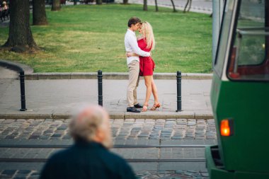akşam güneşli sokak yol kucaklayan aşık güzel mutlu çift. yavaşça sarılma, profesyonel dansçılar elbise şık hipster damat ve kırmızı sarı gelin. Yaz aylarında romantik anlar