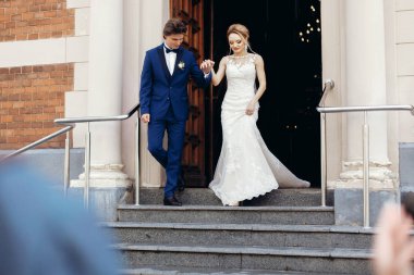 şık gelin ve damat kiliseden sonra kutsal evlilik bağıyla yürüme. mutlu lüks düğün çifti düğün töreni sırasında. romantik an. manevi aşk