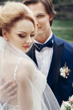 Lüks düğün çifti ışığında eski binasında poz. şık gelin ve damat arıyorum ve şehir sokak kucaklayan. Romantik duygusal an.