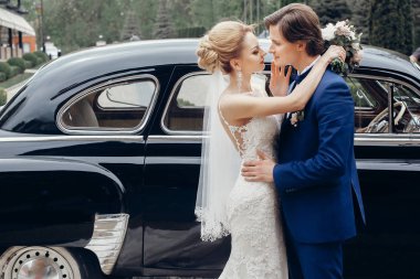 Lüks düğün çifti ışık eski araba dans. şık gelin ve damat sarılma ve şehir sokak kucaklayan. romantik tutkulu şehvetli an. kadın ve erkek birlikte