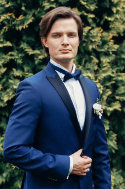 şık damat portre Park. mavi elbiseli bahar parkta poz yakışıklı adam. Beyefendi ya da işadamı resepsiyon açık havada