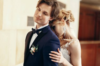 şık gelin ve damat poz ve otel odasında sarılma. mutlu lüks düğün çifti kucaklayan. romantik tutkulu şehvetli an. kadın ve erkek birlikte