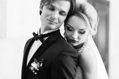 şık gelin ve damat poz ve otel odasında sarılma. mutlu lüks düğün çifti kucaklayan. romantik tutkulu şehvetli an. kadın ve erkek birlikte