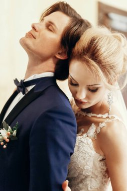 şık gelin ve damat poz ve otel odasında sarılma. mutlu lüks düğün çifti kucaklayan. romantik tutkulu şehvetli an. kadın ve erkek birlikte