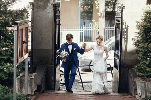 şık damat ve sarılma ve kucaklayan yürüyüş ve şehir sokakta el ele tutuşarak gelin. Düğün günü kavramı. güzel düğün çift, romantik anlar elopment