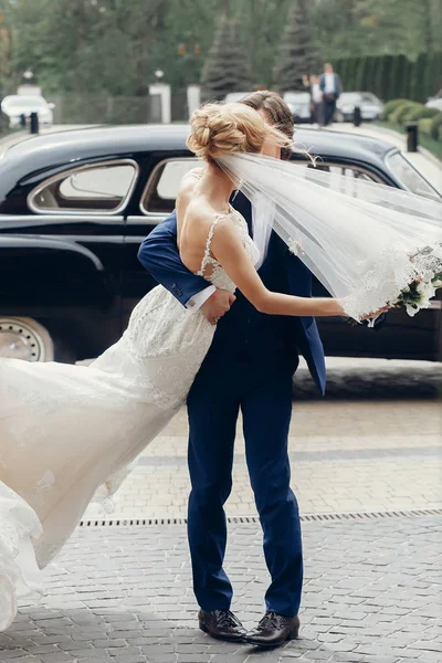 高級結婚式のカップルは古い車の光の中でダンスします スタイリッシュな花嫁と花婿ハグと街を受け入れます ロマンチックな官能的な瞬間 男を探している女性 — ストック写真