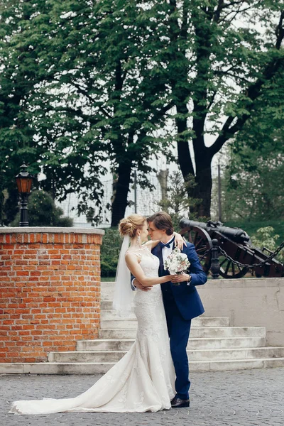 スタイリッシュな花嫁と花婿の街の通りを歩いてします 幸せな贅沢な結婚式を保持している光の手 ロマンチックな官能的な瞬間 男と女のお互いを見て — ストック写真