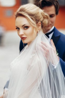 şık gelin ve damat şehir sokak kucaklayan. mutlu lüks düğün çifti ışığında eski binasında sarılma. Romantik duygusal an.