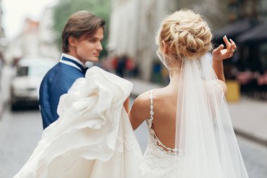 şık gelin ve damat dans ve having fun şehir sokak. mutlu lüks düğün çifti Holding ışıkta eller. Romantik duygusal an. duygusal erkek ve kadın